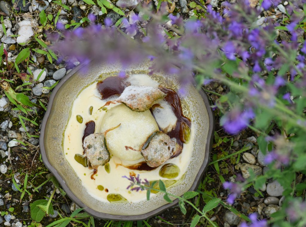 Ein Gericht aus dem Restaurant wird in einer Wiese mit Lavendel präsentiert