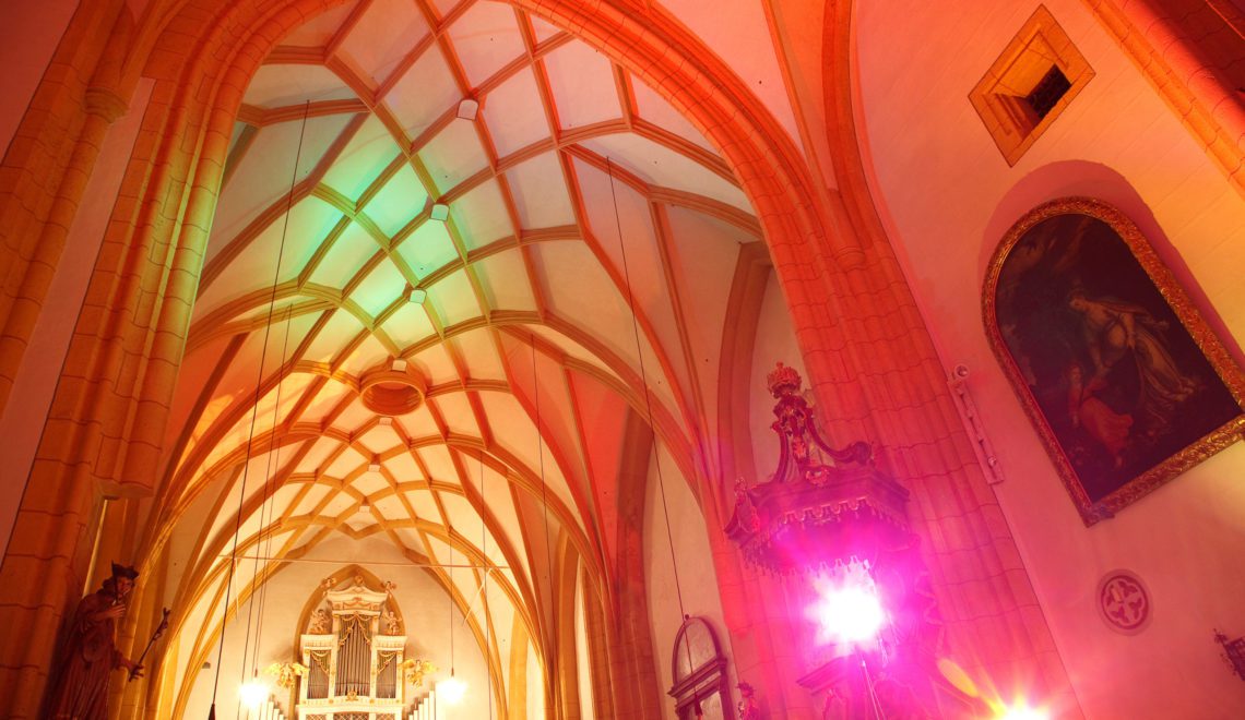 Eine orange-beleuchtete Kirchendecke