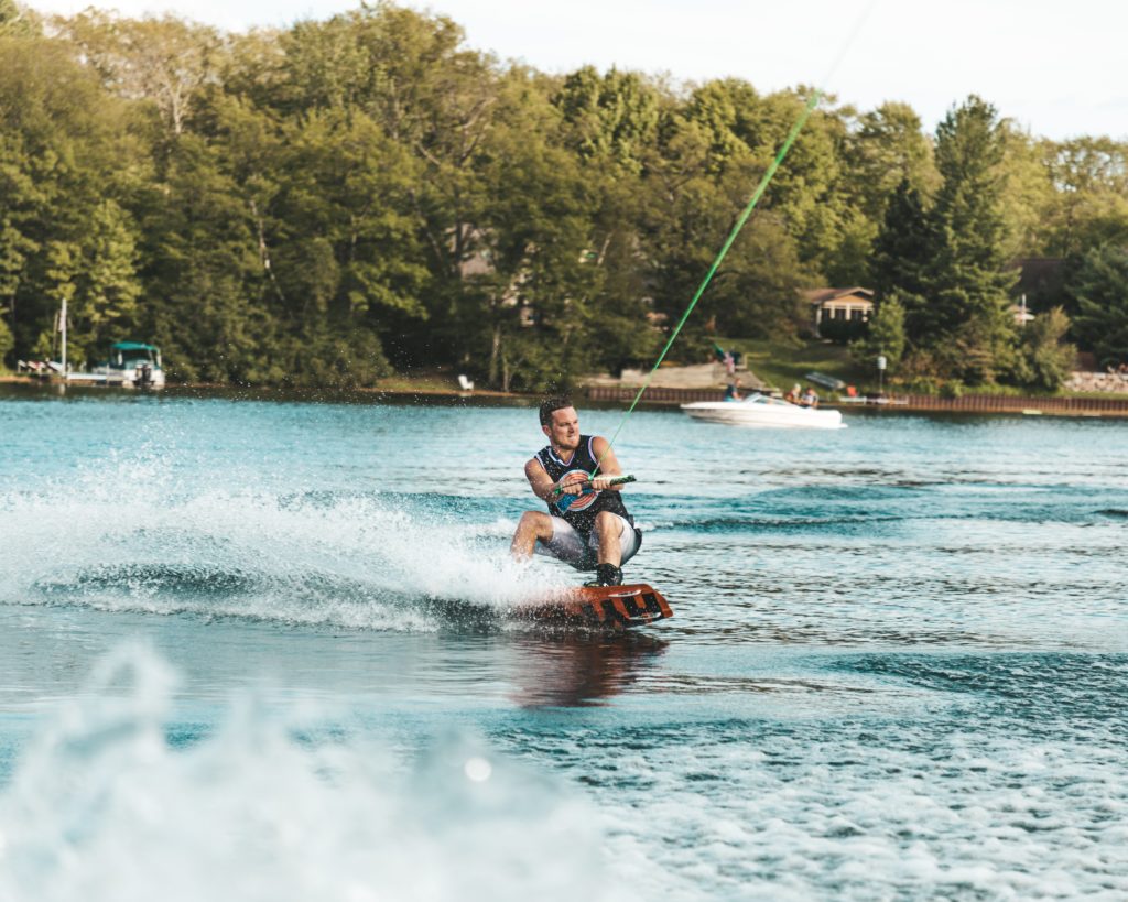 Ein Mann auf einem wakeboard in einem türkisen Gewässer 