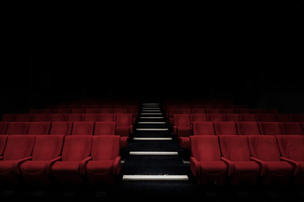 Ein dunkles Theater mit roten Stühlten